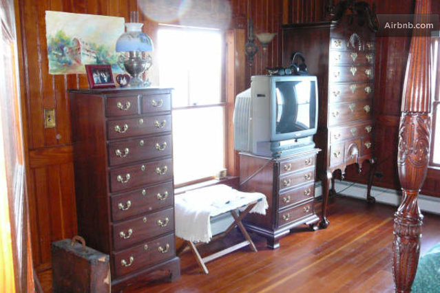 View of the tv and dressers furnished in the master bedroom.